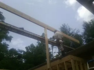 Carpenter setting a ridge beam over a new addition frame — Ice Dam Removal by Roofing Brothers in Altaville