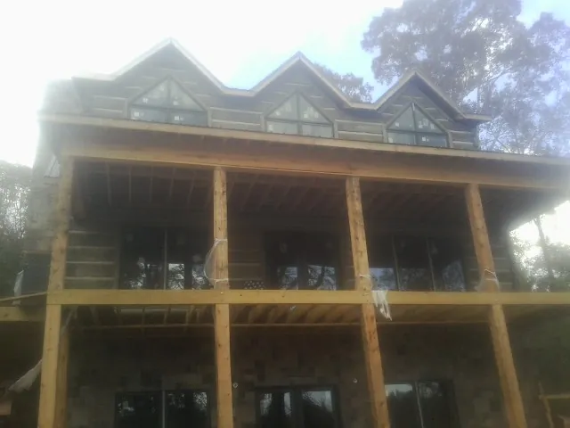 Dormers and porch framing on a large log home under construction — Roof Coating work by our crew in Altaville